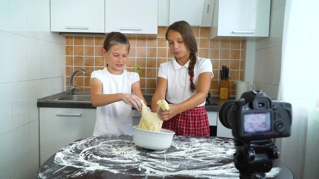 Young vloggers recording video content for food blog preparing for dough kneading. Smart girls live streaming culinary vlog. Communication, healthy food, childhood, handmade, hobby, network concept