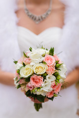Obraz na płótnie Canvas Bride holding a bright wedding bouquet with different flowers