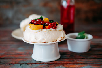 Tasty Pavlova dessert with white meringue, cream and fruit