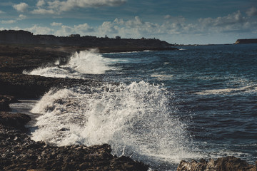 Fototapeta na wymiar Sea wave splashing on rocks, natural holiday vintage hipster seasonal background