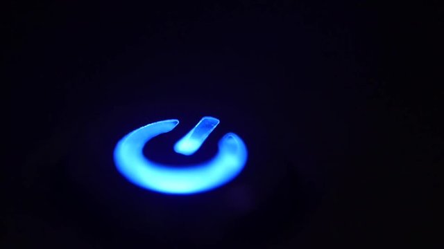 Finger Pressing Illuminated Power Button, Close Up