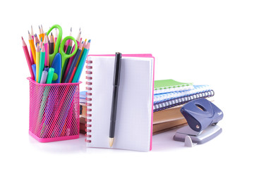 A variety of school supplies including a glass with colored pencils book notebooks a hole notebook notebook with a pen on white isolated background