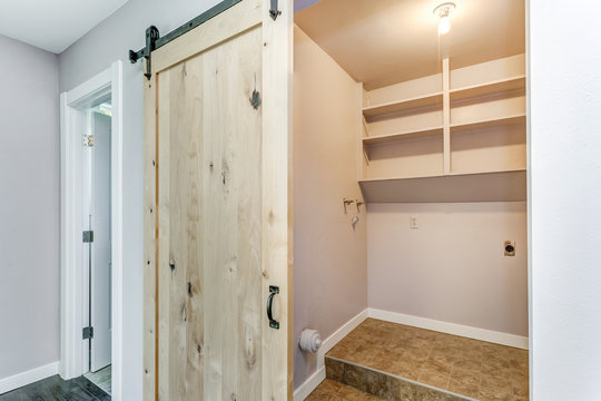 Open Barn Door To A Small Laundry Room.