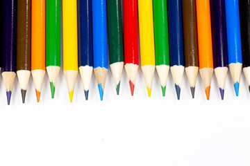 Color pencils lined up in a row against a white background.