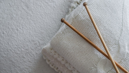 White sweaters and yarn for knitting close up. Knitting needles. Concept Handicraft. Place for text