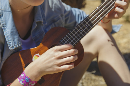 Teenager girl playing ukulele - hawaiian guitar