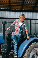 happy child sitting in tractor and looking away on farm