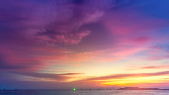 Beautiful colorful purple pink orange blue sunset over ocean. Bright colors. Nature landscape. Holidays, travel, vacation. Water waves move and clouds in sky flow. 4K Slow Motion Time Lapse Parallax