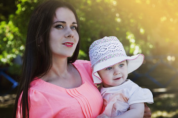 Obraz premium Mom and daughter on the background of the garden