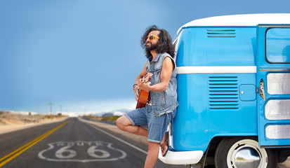 road trip, travel and music concept - hippie man playing guitar and singing at minivan car over us...