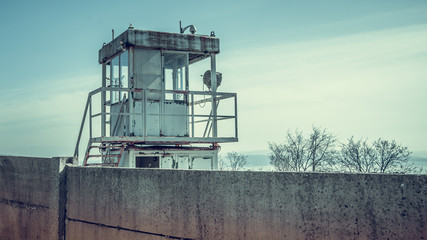 Landscape view of old metal rusted watchtower in old abandoned industrial zone.