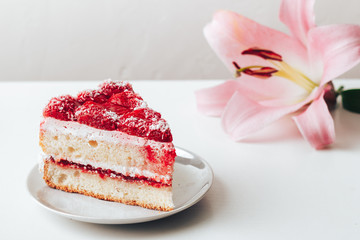 Strawberry cake on a white background and a pink flower