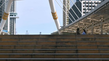 Time lapse of moving business people on the street of urban city with blue sky in background. Finance concept.