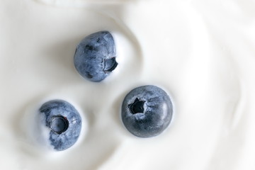 Yogurt and fresh berries blueberries, background. Flat lay, top view, copy space 