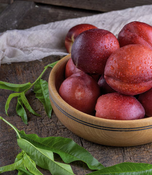 ripe peaches nectarine in a brown wooden bowl