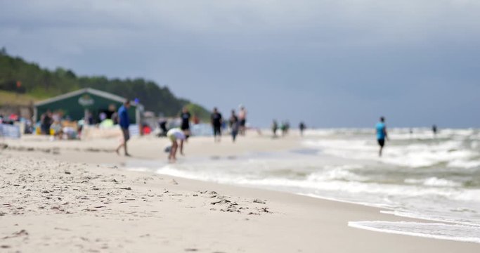 Unrecognizable people resting on the beach of Baltic Sea.