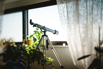 Luxury house interior with wide glass windows and amateur telescope