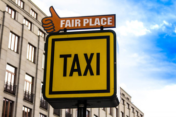 Obraz premium Information sign of a Taxi and Fair place on the background of houses in Prague
