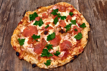 Homemade fresh delicious gourmet pizza whit salmon, garlic and fresh parsley,Tasty italian pizza isolated on wooden table,Close up with selective focus
