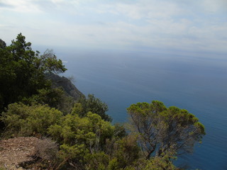 An amazing caption of the beautiful places from the 5 Terre in Liguria with an amazing blue sky and some green mountains in the background