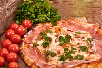 Homemade fresh delicious gourmet pizza whit shrimps, porcini mushrooms, speck, garlic and fresh parsley,Tasty italian pizza isolated on wooden table,Close up with selective focus