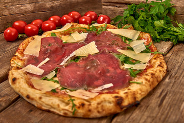 Homemade fresh delicious gourmet pizza whit carpaccio matured beef, rocket and slices of grana...