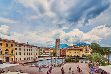 Obraz premium Riva del Garda,Lago di Garda ,Italy - 25 May 2018:View of the beautiful Riva del Garda town, Panorama of the gorgeous Garda lake surrounded by mountains in the in the spring on a stormy day