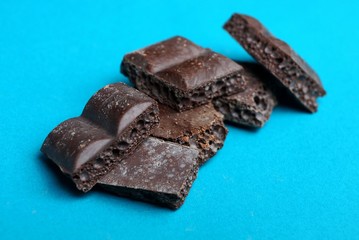 pieces of brown porous chocolate on a blue background