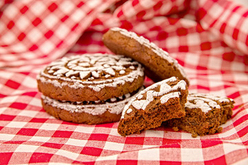 pile of gingerbreads with two broken pieces on red and white tradational tablecloth