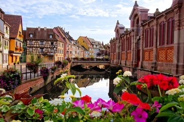 Colorful half timbered houses along a canal with flowers and reflections, Colmar, Alsace, France