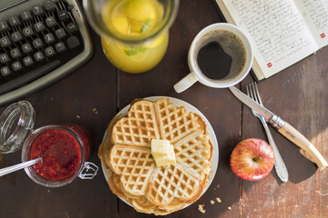 breakfast with waffle, butter, coffee, apple and lemonade