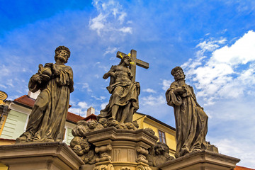 Fototapeta premium Sculpture of Holy Savior with Cosmas and Damian on the Charles Bridge in Prague. Czech Republic.