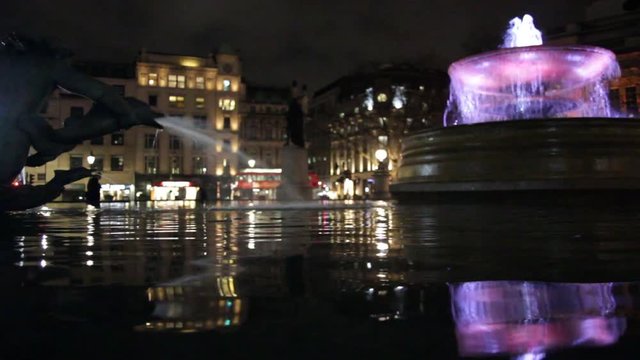 LONDON, Trafalgar Square at night fountains with bright lights real time tourism landmark