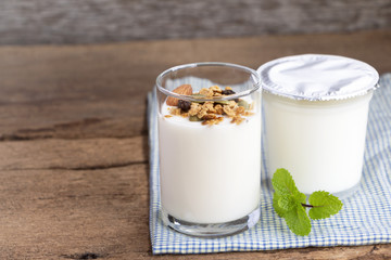 A breakfast of yogurt with dried fruit put on a wooden table.