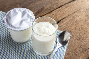 A breakfast of yogurt with a spoon placed on a wooden table.