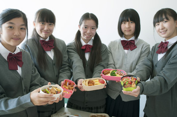お弁当を持ち微笑む中学生