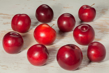 Ripe red plums on an old table