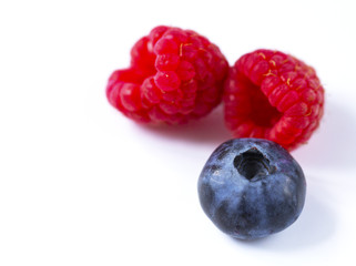 Close-up arrangement mixed, assorted berries including blackberries, strawberry, blueberry, raspberries and fresh leaf on white