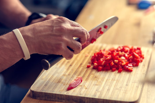 Chopping vegetables on a wooden board at home. Shallow depth of field.