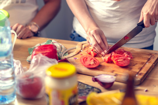 Chopping vegetables on a wooden board at home. Shallow depth of field.