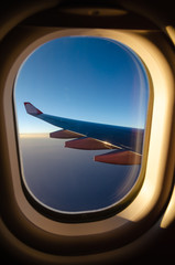 Outside the window's airplan sunset seen with aircraft wing.