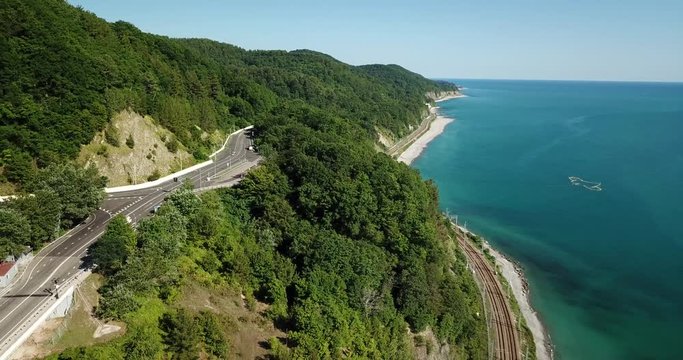 4K aerial stock footage of car driving along the winding mountain pass road through the forest in Sochi, Russia. People traveling, road trip on curvy road through beautiful countryside scenery.