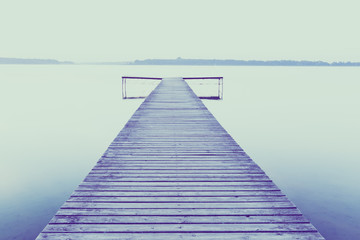 Old empty wooden jetty on lake, during sunrise.