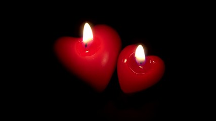 Couple of two candles in the heart shape lighting together, blowing candle, end love, remain in the dark