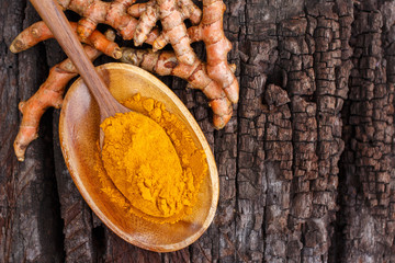 Turmeric powder in wooden bowls on wooden table