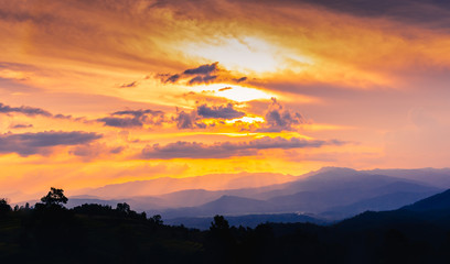 Dramatic and colourfull sunset with mountains and forest.