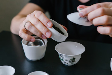 Chinese tea ceremony, tea master pouring black tea into gaiwan