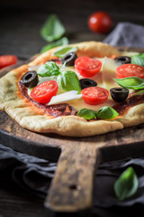 Homemade pizza with tomatoes, cheese and olives