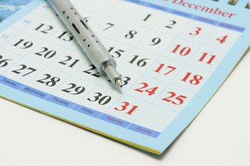 Pen of metal  on a calendar.