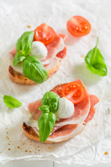 Homemade bruschetta with mozzarella, prosciutto and tomato